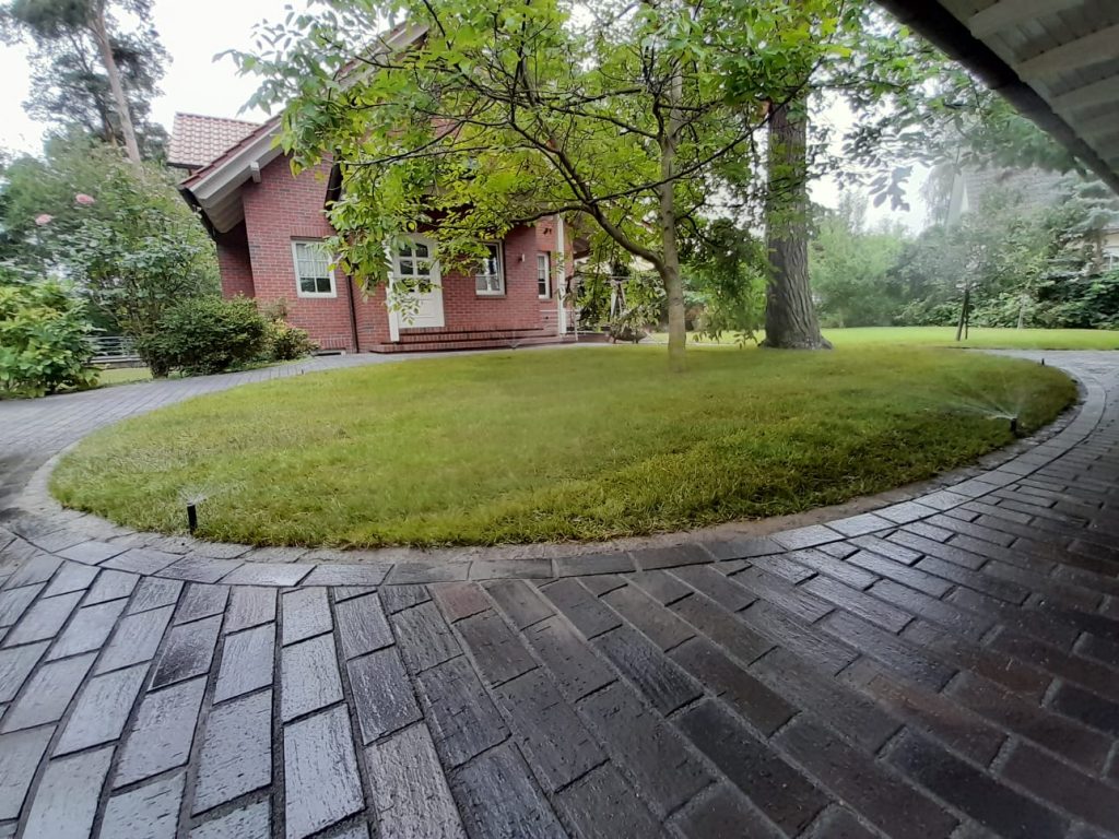 Gepflasterte Hofeinfahrt mit runder Rasenfläche – Garten- und Landschaftsbau in Wildau