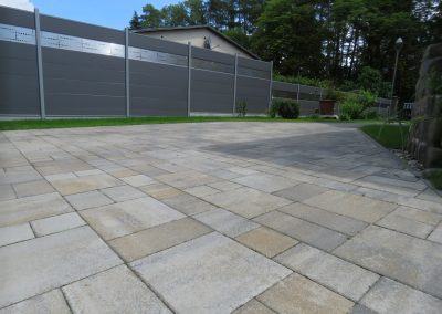 Große Pflasterfläche im Garten mit Sichtschutzzaun – Referenz GALABAUM MEINKE