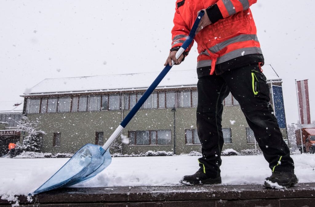 Mitarbeiter beim Schneeräumen mit der Schneeschaufel